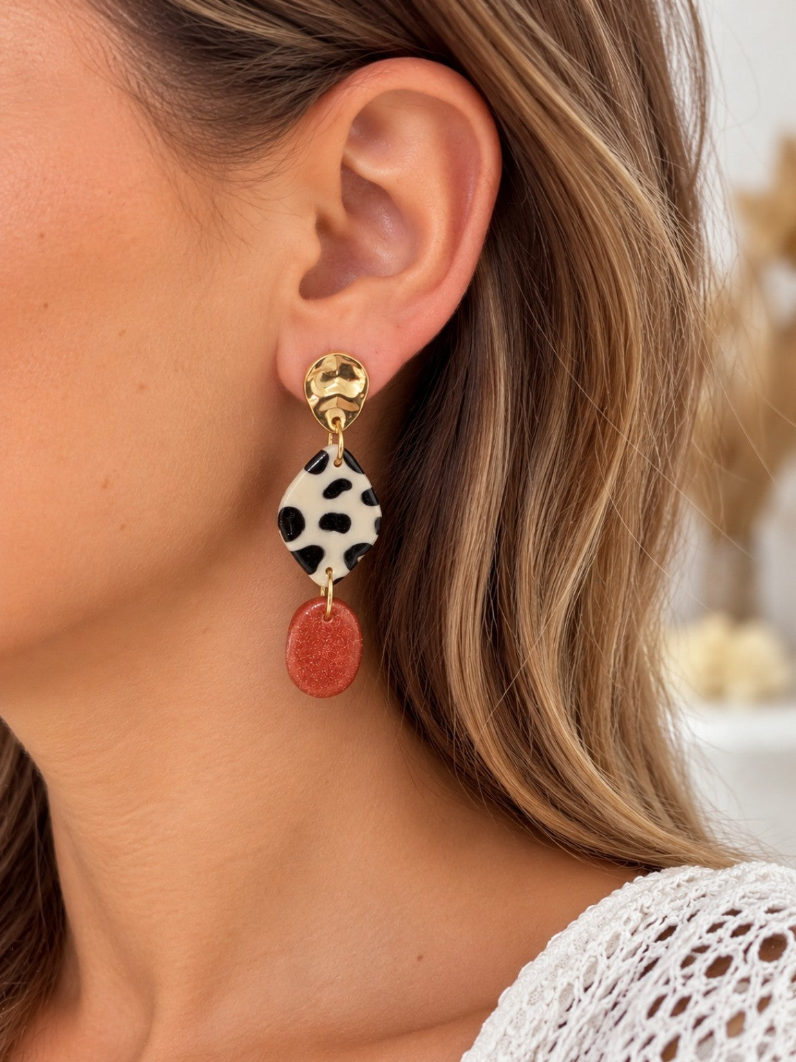Boucle d’oreille portée d’une paire asymétrique léopard et terracotta métallisé, création Créa Gégé
