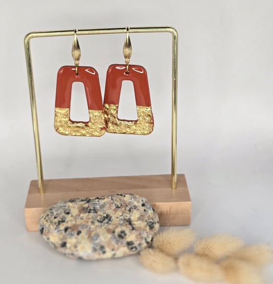 Boucles d’oreilles incrustées de feuilles d’or.